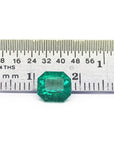 GIA certified emerald-cut loose Muzo Colombian emerald next to a ruler for measuring size