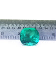 Cushion cut loose natural Colombian emerald GIA certified, front on a ruler for measuring size