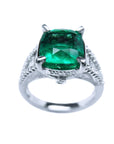 A gia certified cushion cut emerald ring for women in 18k white gold, top profile and sides visibles.