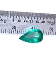 2.77 carat GIA certified pear cut Colombian emerald with vivid deep bluish-green hue, next to a ruler.