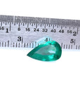 2.77 carat GIA certified pear cut Colombian emerald with vivid deep bluish-green hue, next to a ruler.