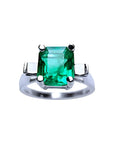 A GIA certified May's birthstone square emerald ring with side princess cut diamonds in 14k white gold.