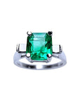 A GIA certified May's birthstone square emerald ring with side princess cut diamonds in 14k white gold.
