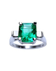 A GIA certified May's birthstone square emerald ring with side princess cut diamonds in 14k white gold.
