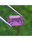 4.05 ct natural loose pink sapphire, emerald cut, held by tweezers.