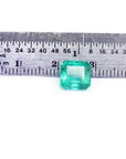 GIA certified 2.23 carat square octagonal Muzo Colombian emerald with vivid bluish-green hue, shown next to a ruler.