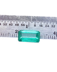 2.47 carat GIA certified loose Colombian emerald, sparkling bluish-green, rectangular cut, displayed against a ruler.