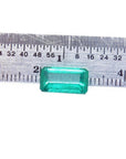 2.47 carat GIA certified loose Colombian emerald, sparkling bluish-green, rectangular cut, displayed against a ruler.