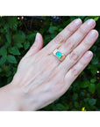 Men's 14K yellow gold ring with an east-west emerald-cut Colombian emerald and channel-set diamonds.