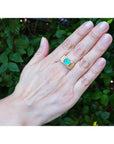 Men's 14K yellow gold ring with an east-west emerald-cut Colombian emerald and channel-set diamonds.