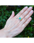 Men's 14K yellow gold ring with an east-west emerald-cut Colombian emerald and channel-set diamonds.