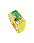 The half-side profile of a gold ring for men with a rectangular colombian emerald and small diamonds on a white background