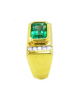 Men's 14K yellow gold ring with an East-West emerald-cut Colombian emerald and channel-set diamonds.