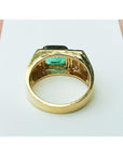 The underside view of a yellow gold men's emerald ring on a white background.