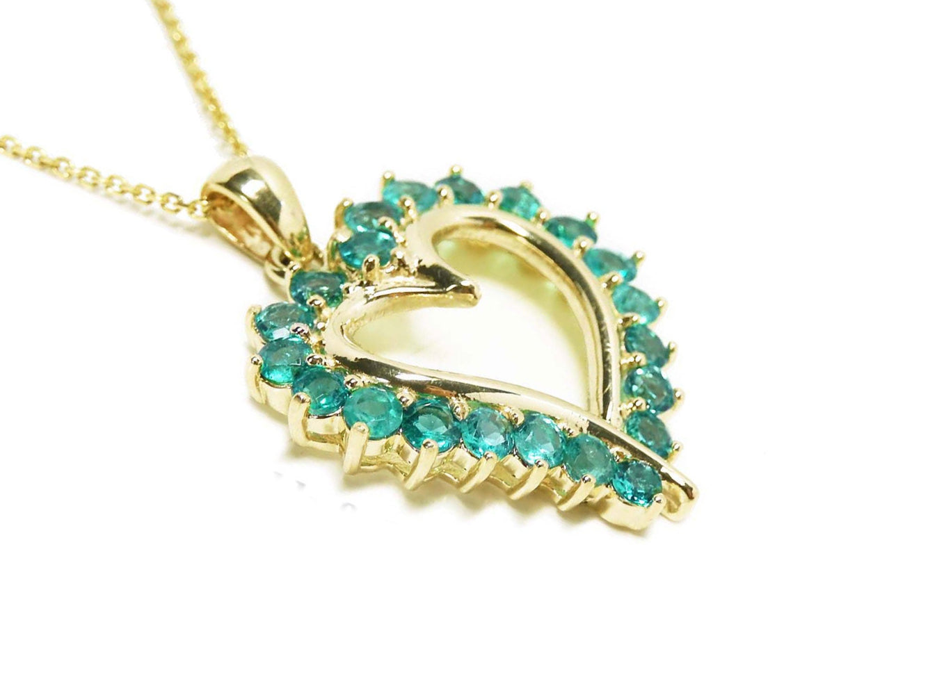 Gold heart-shaped pendant with round emerald gemstones on a side profile view.
