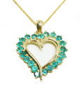 Heart-shaped pendant with emerald stones on a gold chain topside view.