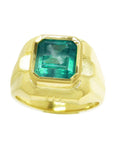 A yellow gold men's ring with a natural square colombian emerald in bezel set displaying the topside view.