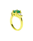 18k gold ring with a 1.51 ct. oval emerald and two trillion-cut side diamonds.
