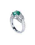 Natural oval emerald ring in 18K white gold with a decorative bridal-style band.
