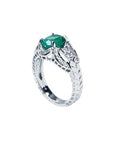 Natural oval emerald ring in 18K white gold with a decorative bridal-style band.