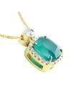 Cushion-cut emerald pendant with diamond halo on an 18K yellow gold chain.