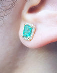 Close-up of an ear wearing a Colombian emerald stud earring.