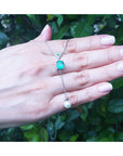 1.91 carat emerald cushion cut necklace with a hanging white freshwater pearl on 14K white gold.