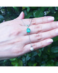 1.91 carat emerald cushion cut necklace with a hanging white freshwater pearl on 14K white gold.