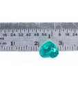 1.26 ct. heart cut Colombian emerald with vibrant bluish-green color, shown next to a ruler for scale.