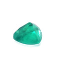 1.26 ct heart cut Colombian emerald with vibrant bluish-green color on a white background.