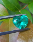 GIA certified 2.54 carat heart-cut Colombian emerald, sparkling bluish-green, held by tweezers.