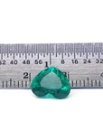GIA certified 2.54 ct heart-cut natural Colombian emerald, sparkling bluish-green, on a ruler.