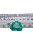 GIA certified 2.54 ct heart-cut natural Colombian emerald, sparkling bluish-green, on a ruler.