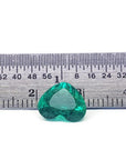 GIA certified 2.54 ct heart-cut natural Colombian emerald, sparkling bluish-green, on a ruler.