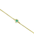 14K yellow gold bracelet with a heart-shaped emerald surrounded by sparkling diamonds.