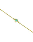 14K yellow gold bracelet with a heart-shaped emerald surrounded by sparkling diamonds.