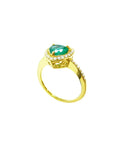 Heart-cut emerald ring with diamond halo and pavé band in 14K yellow gold.