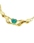 14k yellow gold Claddagh necklace with a heart-shaped green gemstone on a white background