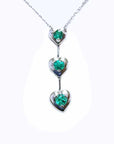 A three hearts emerald journey pendant necklace in 14j white gold.