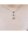 14K white gold heart emerald journey pendant necklace with three round-cut Colombian emeralds.