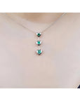 14K white gold heart emerald journey pendant necklace with three round-cut Colombian emeralds.