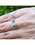 14K white gold heart journey pendant necklace with three round-cut Colombian emeralds.