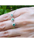 14K white gold heart journey pendant necklace with three round-cut Colombian emeralds.