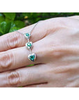14K white gold heart journey pendant necklace with three round-cut Colombian emeralds.