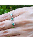 14K white gold heart journey pendant necklace with three round-cut Colombian emeralds.