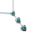Three hearts emerald journey pendant necklace in 14k white gold topside view.
