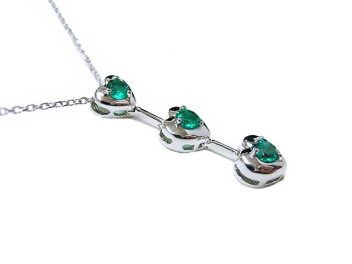 A three links heart shaped journey pendant with round cut emeralds top and side profile view.
