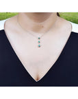 Heart emerald journey pendant necklace in 14K white gold, worn on a woman's neck.