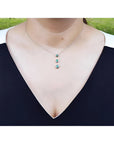 Heart emerald journey pendant necklace in 14K white gold, worn on a woman's neck.