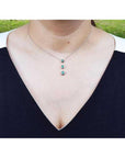 Heart emerald journey pendant necklace in 14K white gold, worn on a woman's neck.